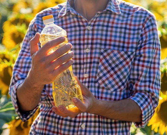 Sunflower oil in the hands of a male farmer on the field. Selective focus.