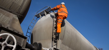 Railway Worker Climbing onto a Tanker Wagon